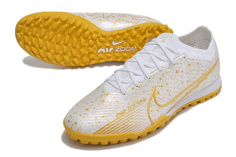 CHUTEIRA NIKE MERCURIAL AIR ZOOM VAPOR 15 ELITE SOCIETY - BRANCA E DOURADA